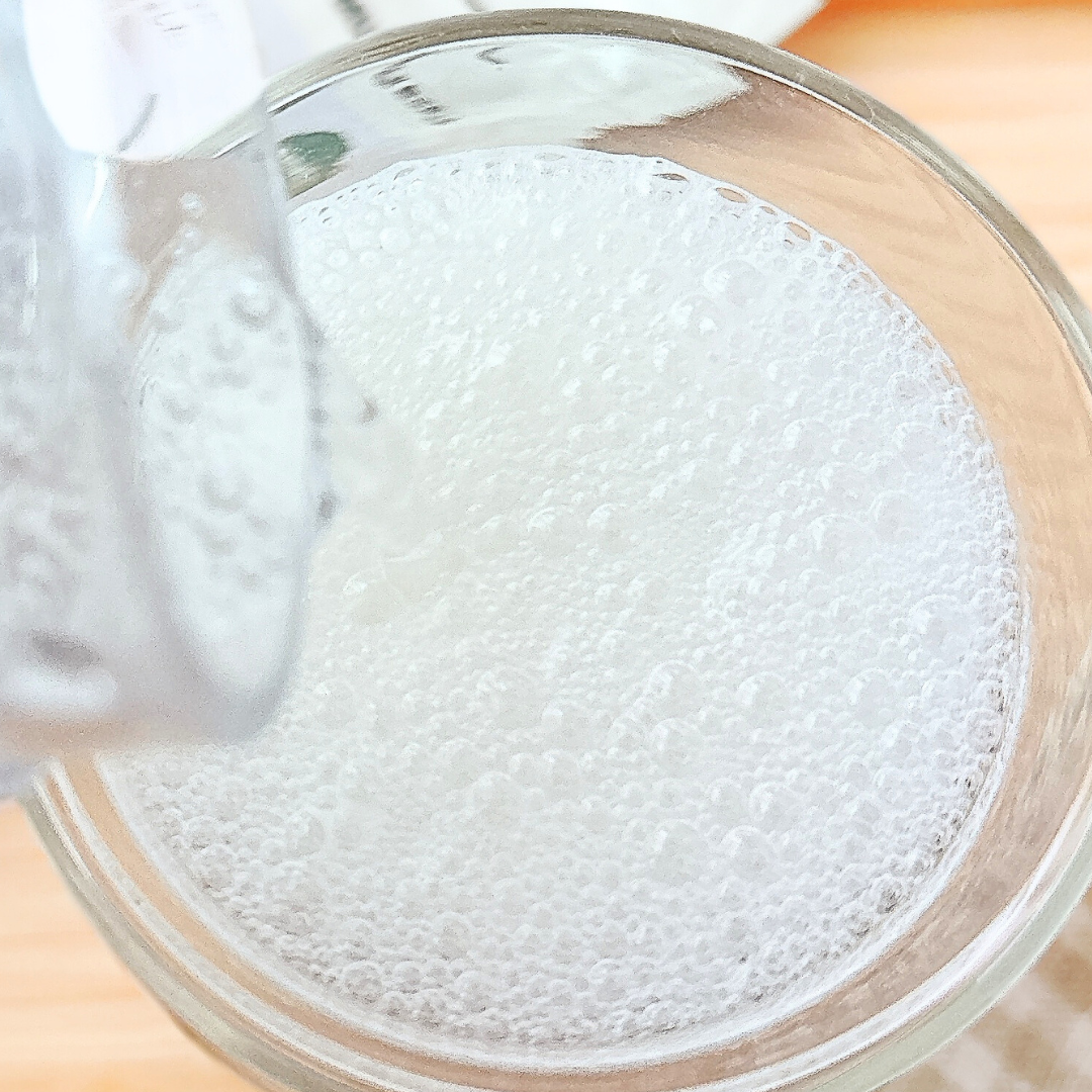 グラスに炭酸水が注がれている様子。泡が立ち上っている。