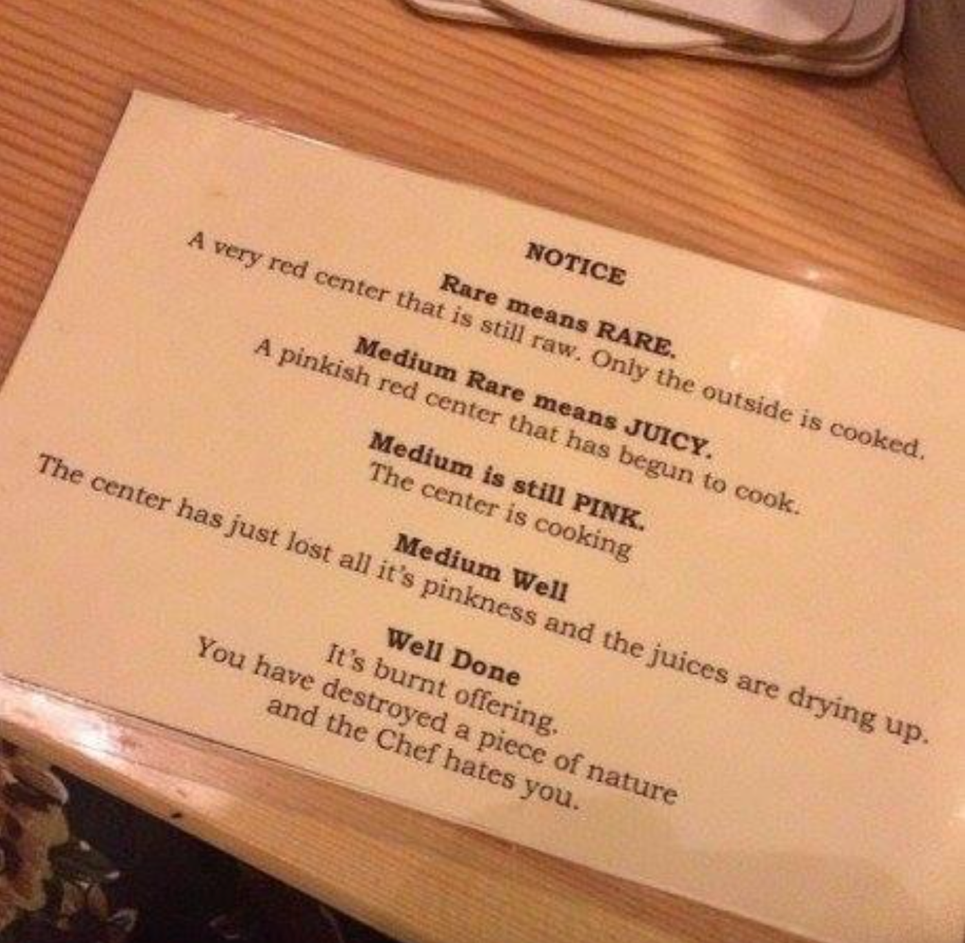 Sign explaining steak doneness: Rare is raw with cooked outside; Medium Rare has a juicy, pink center; Medium has a pink center; Well Done is fully cooked