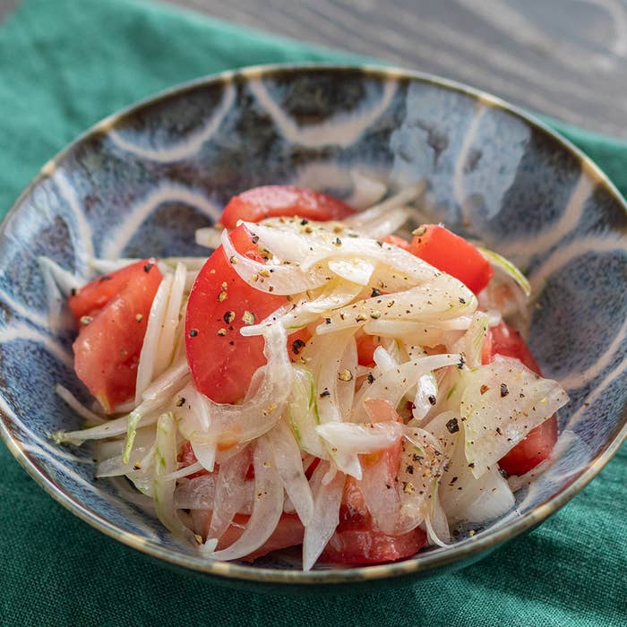 玉ねぎとトマトの和風サラダ。ボウルに盛られ、黒コショウが振られている。