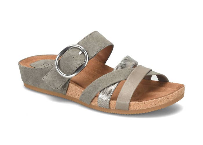 Slip-on sandal with a cork sole features strap design and large buckle, ideal for casual outings and comfortable wear