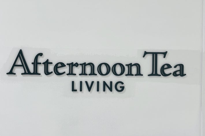 壁に「Afternoon Tea LIVING」と書かれた看板。静かなショッピングエリアの一部。