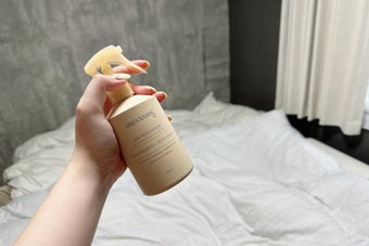 ベッドルームで、誰かがエアフレッシュナーを持っている様子。