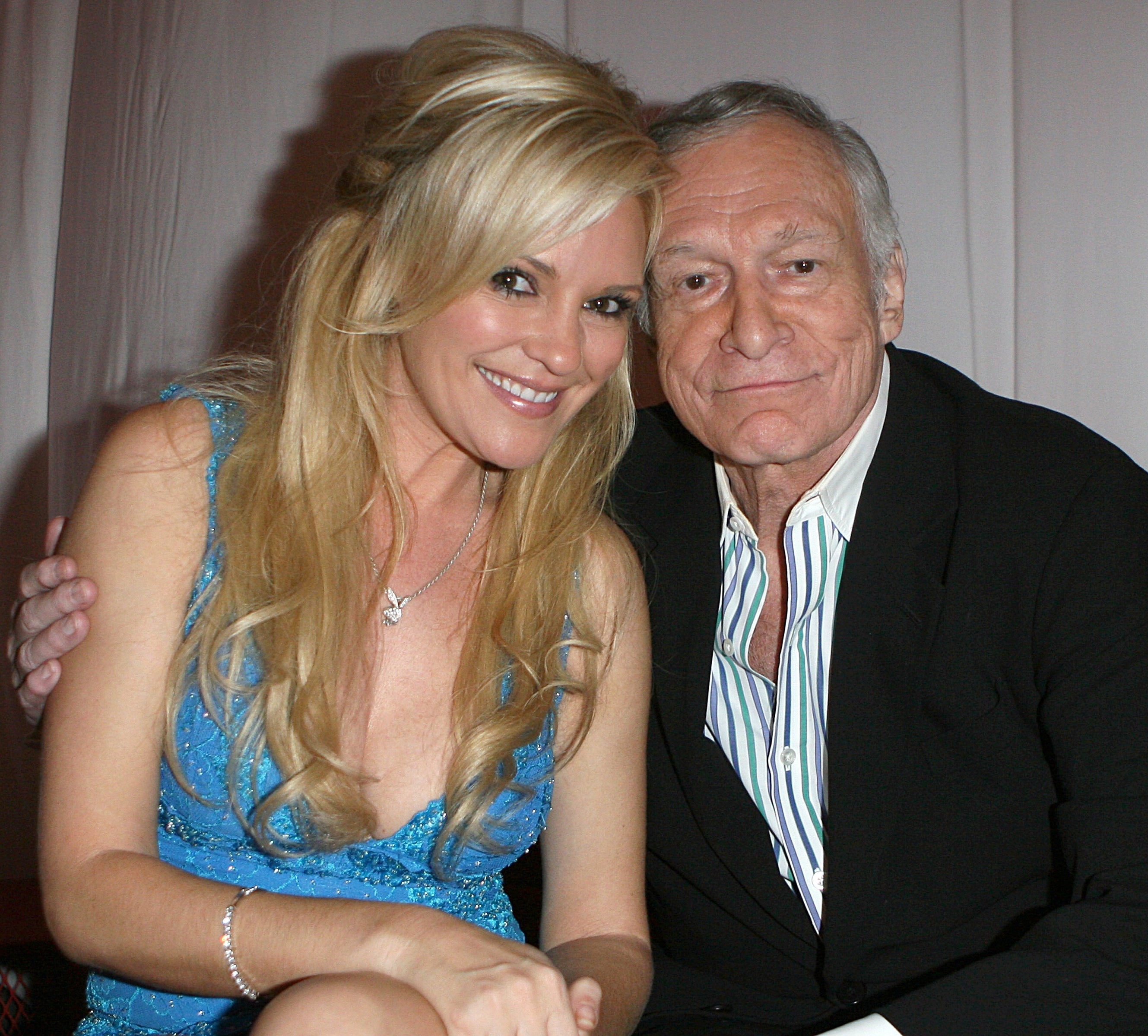 Bridget Marquardt and Hugh Hefner sitting together, posing for the camera