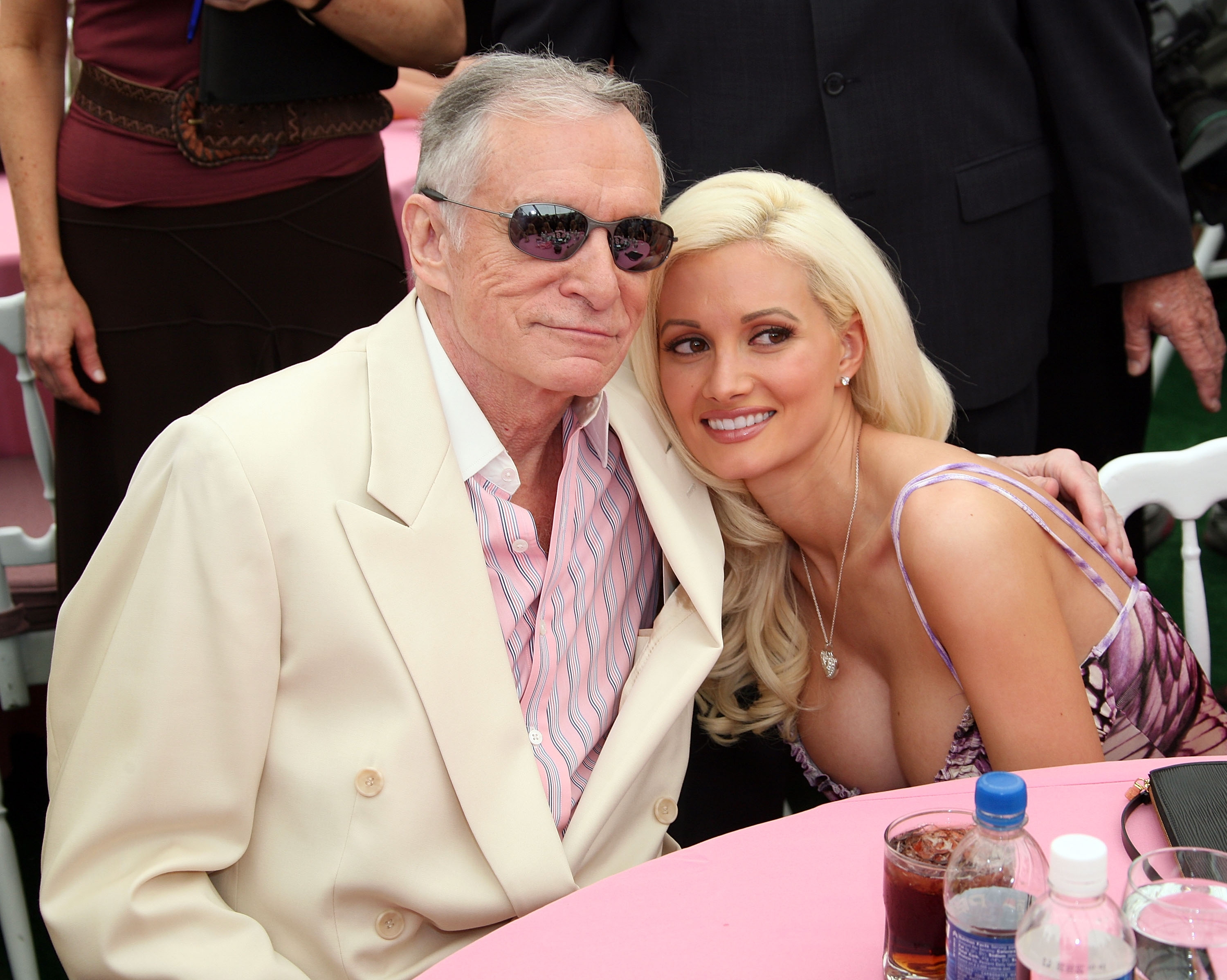 Hugh Hefner and Holly Madison outdoors, seated closely at an event
