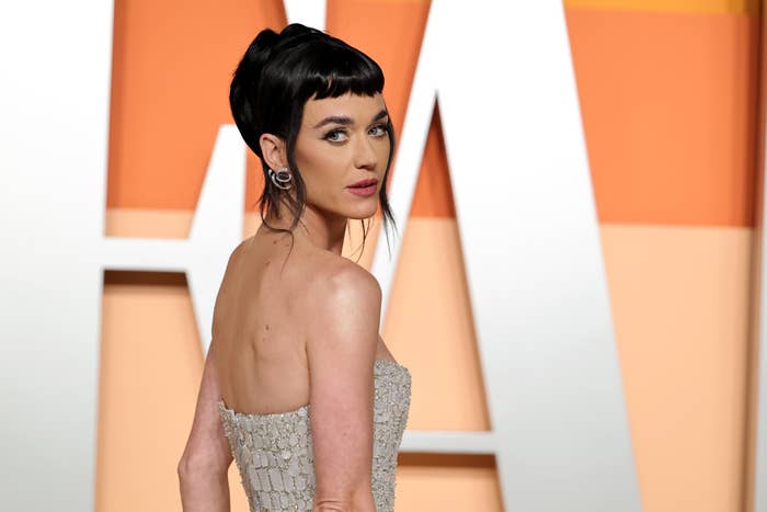 Person successful elegant strapless formal with sleek updo poses connected reddish carpet astatine a personage event
