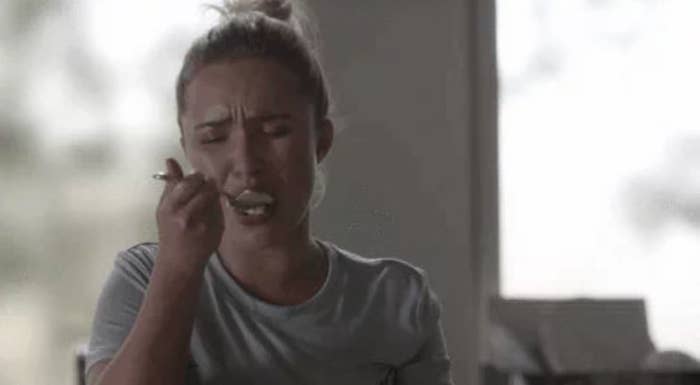 Person successful a casual garment eating from a spoon, appearing emotional. Indoor setting