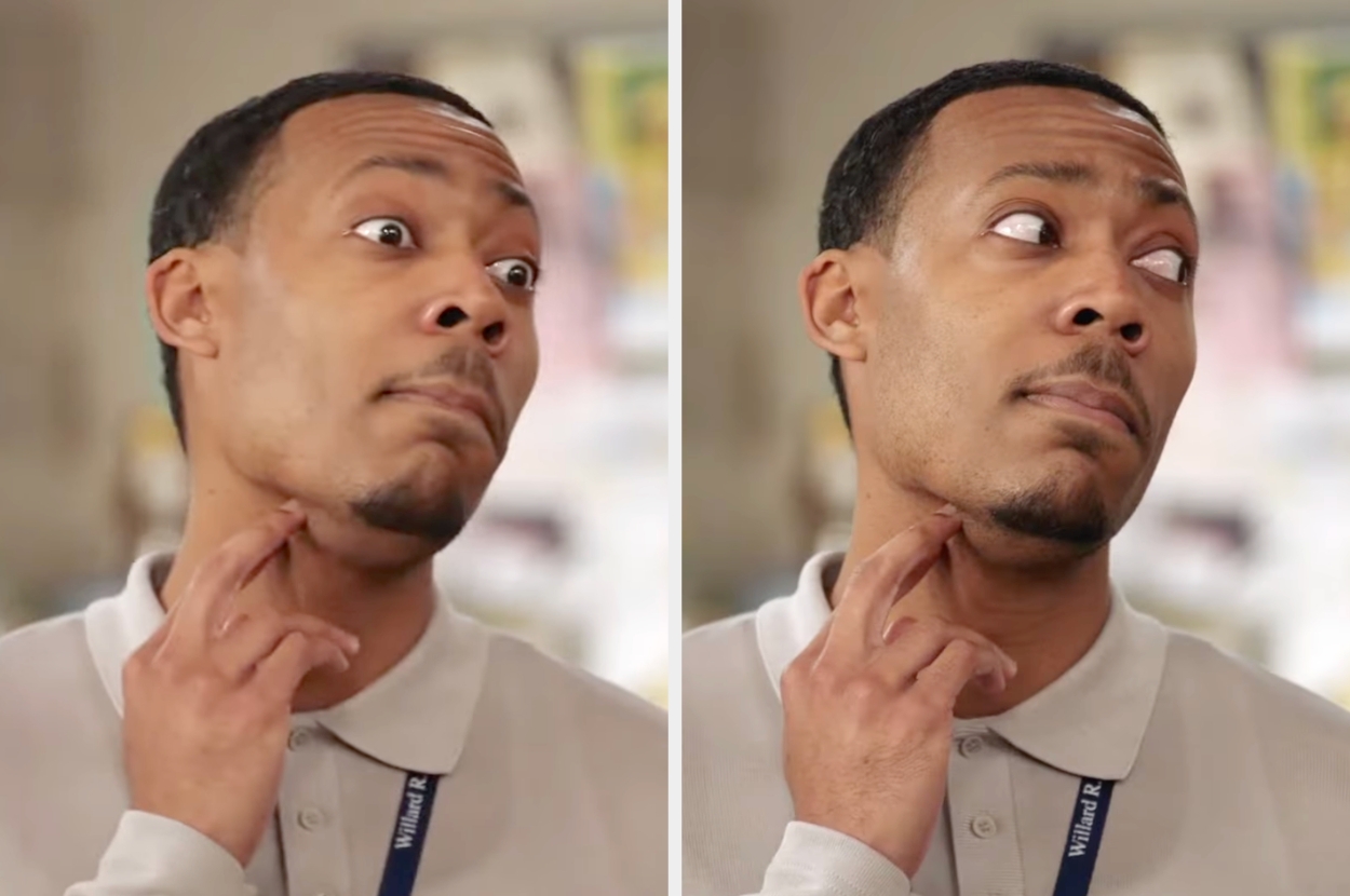 Tyler James Williams in a collared shirt scratches his neck with a curious expression, looking upward