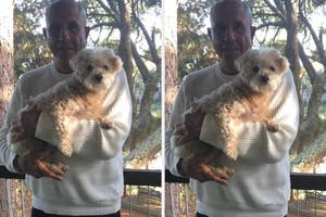 Man holding a small fluffy dog outdoors with trees in the background