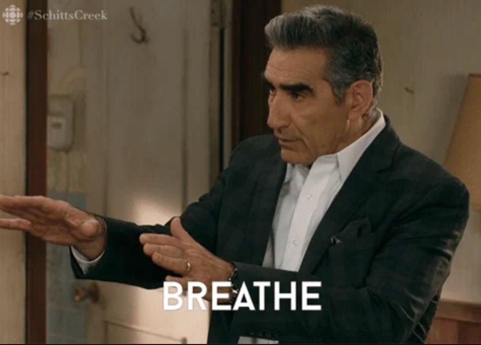 Man in a suit gesturing calmly with text "BREATHE," suggesting a relaxed approach