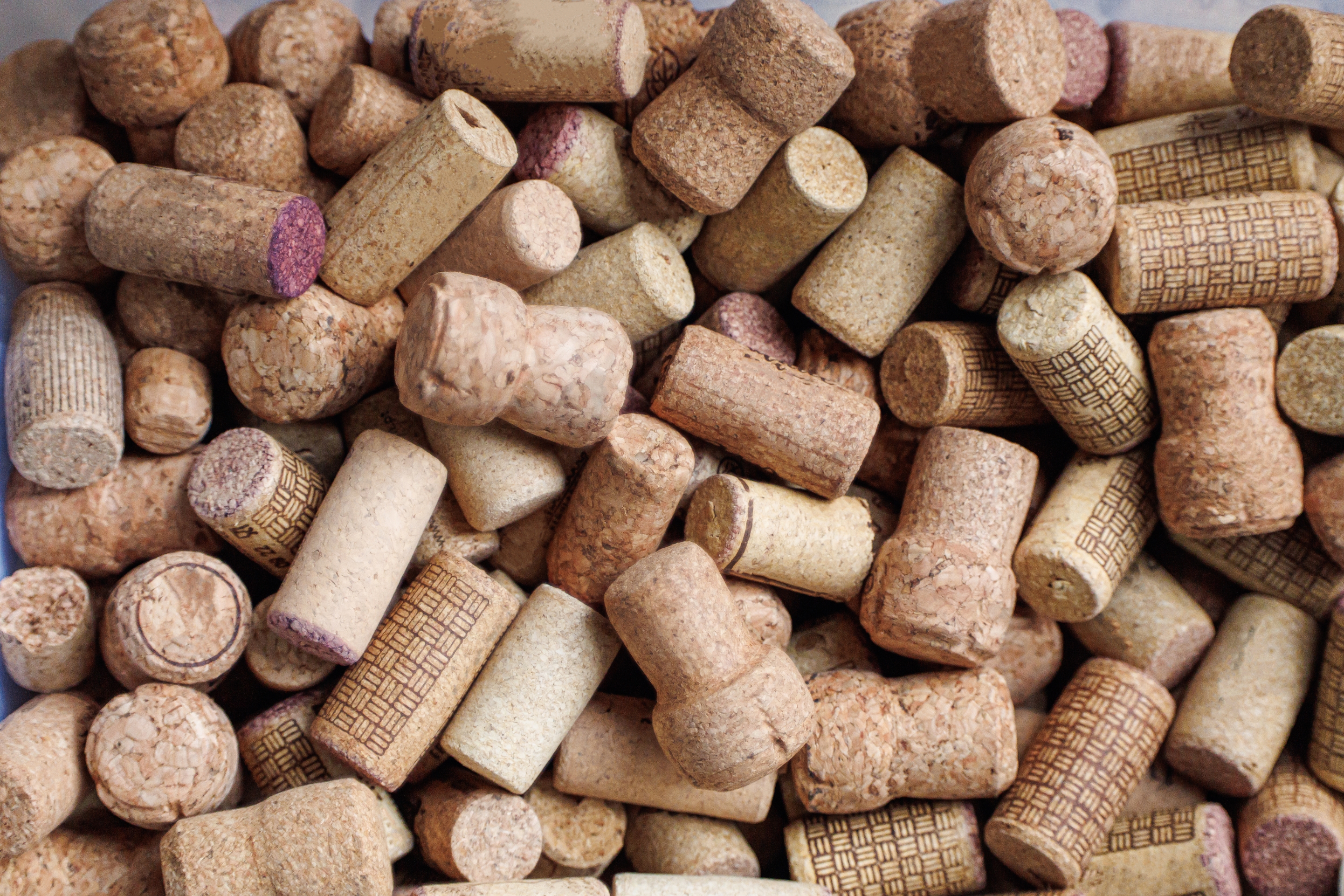 A pile of assorted wine corks, both natural and synthetic, in various shapes and textures
