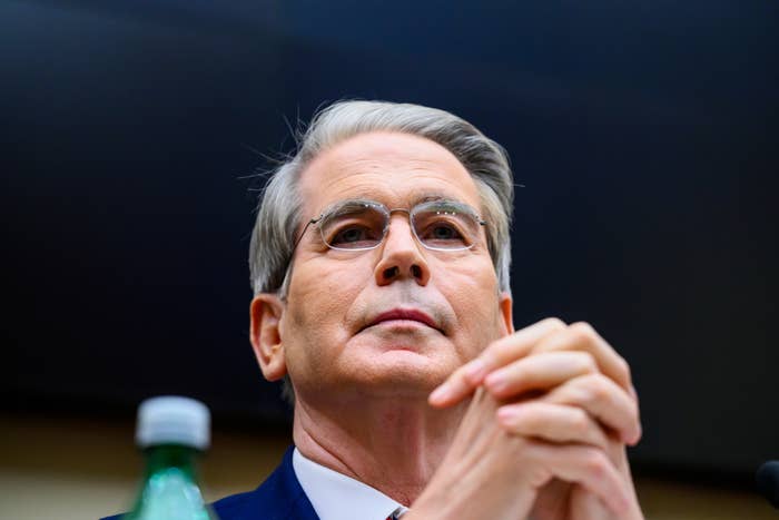 Scott Bessent with glasses sits with hands clasped during a Senate hearing