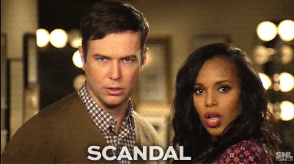 Two actors in a TV promo for "Scandal" stand together, looking directly at the camera with expressions of surprise