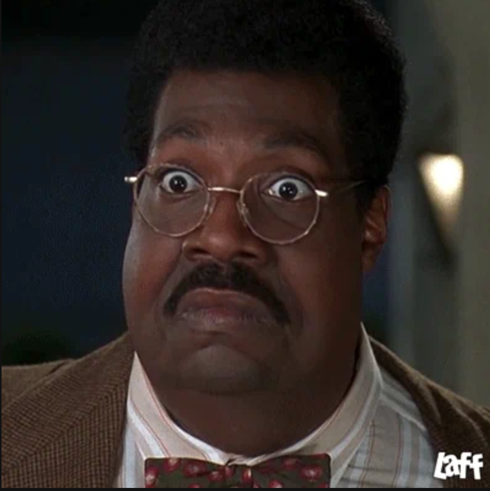 Man with glasses and a surprised expression, wearing a suit and bow tie