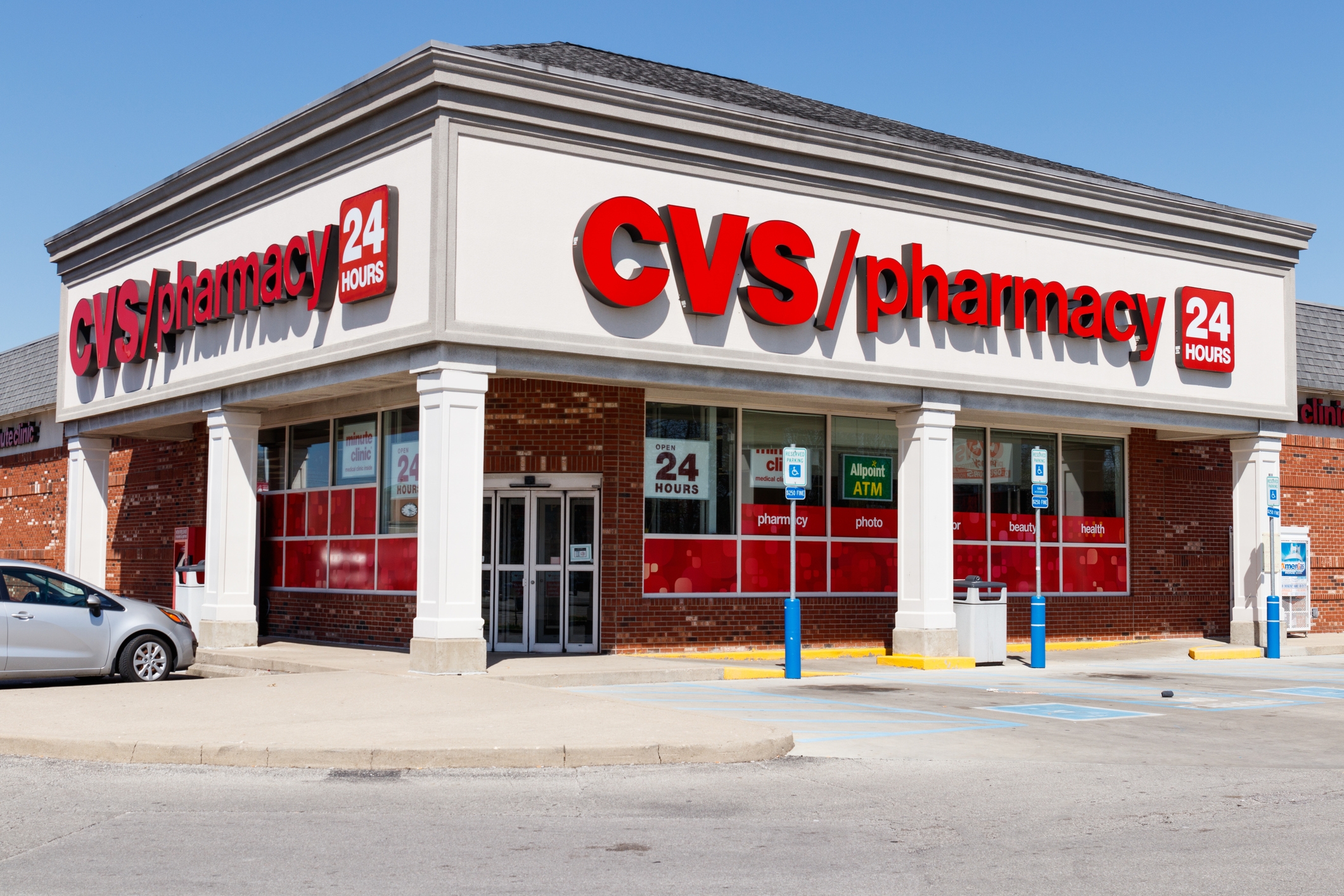 CVS Pharmacy storefront with 24-hour signage, located on a street corner with nearby parking
