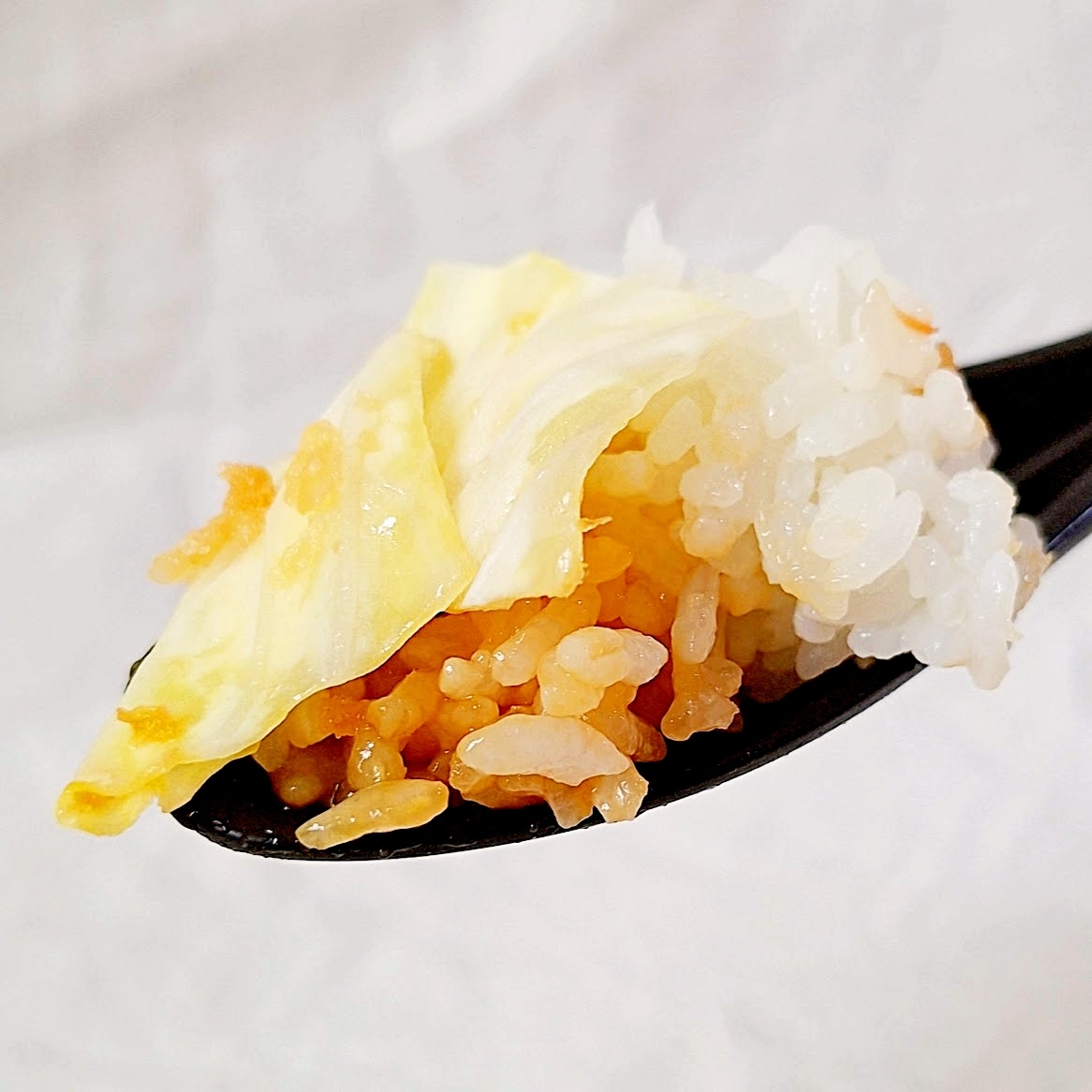 スプーンに盛られたご飯とキャベツ。