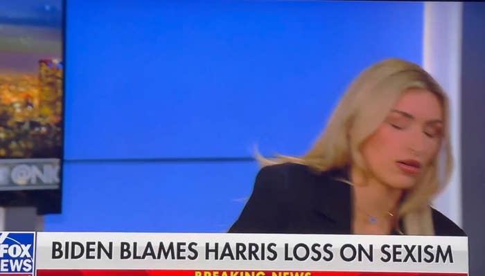 Woman sitting connected a quality acceptable with the header "Biden Blames Harris Loss connected Sexism" displayed connected screen