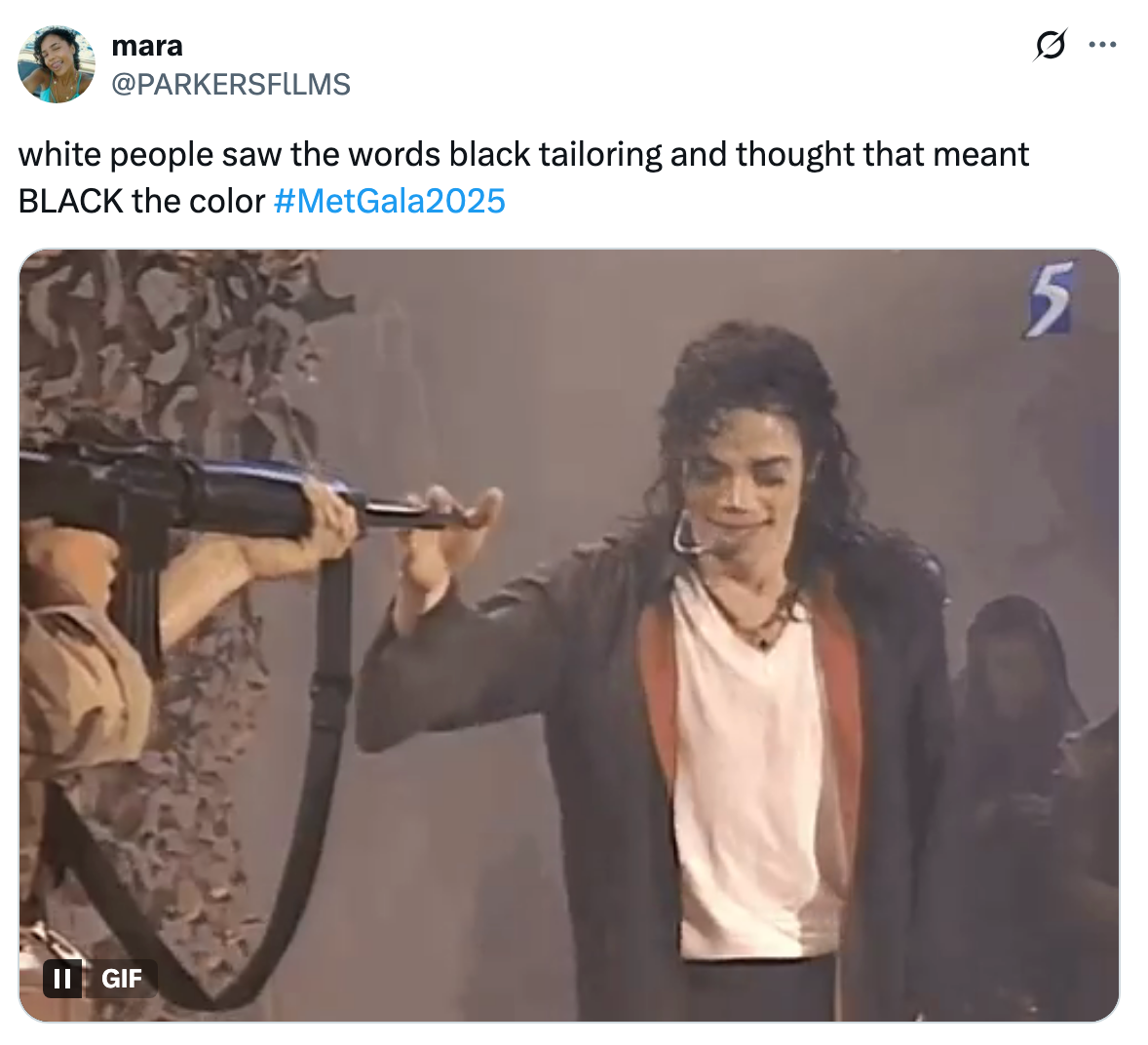 A GIF of a person in a suit with a white shirt, holding a microphone. Text above reads a humorous comment about misunderstanding "black tailoring" at #MetGala2025