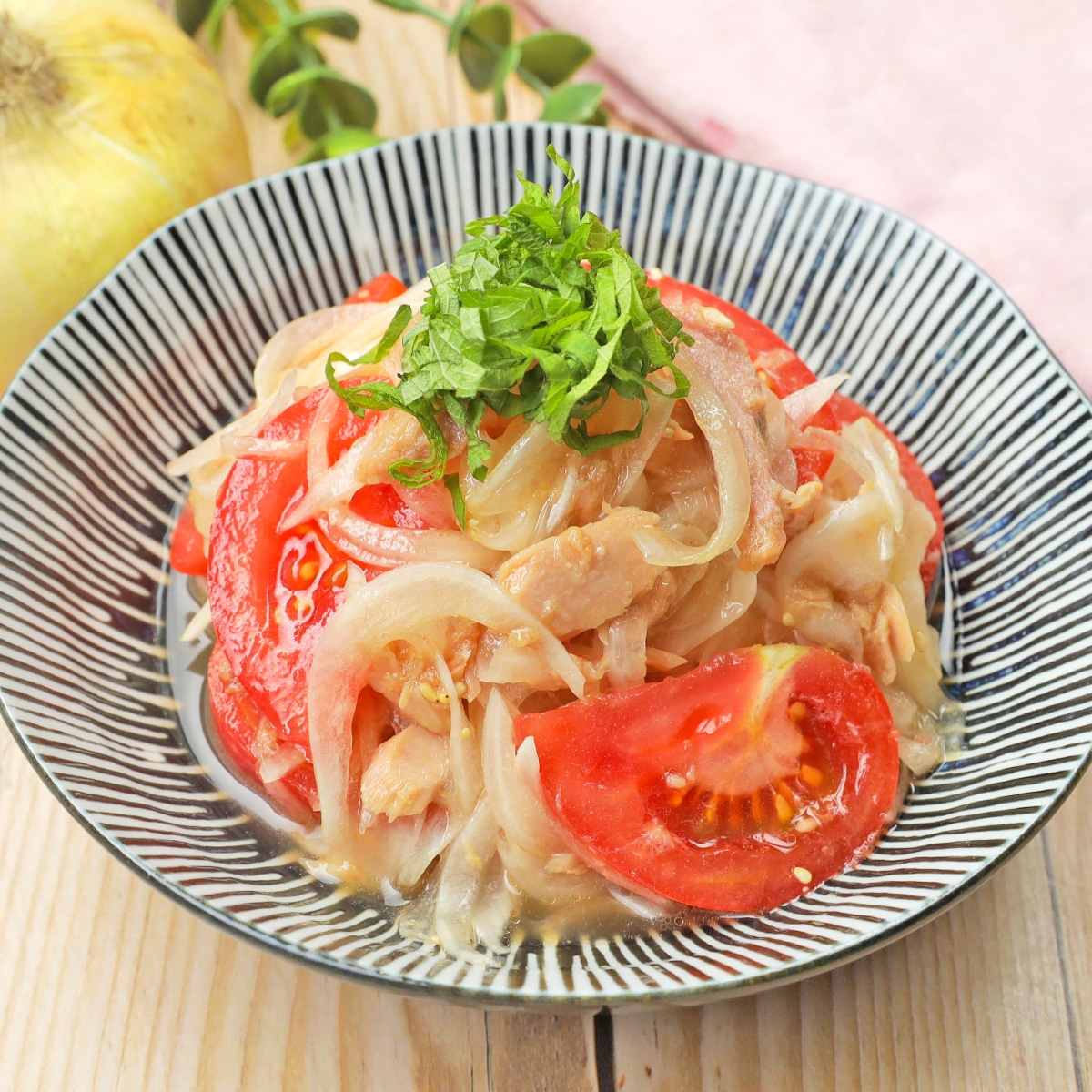 トマト、玉ねぎ、肉が盛られた皿。刻んだハーブがトッピングされています。