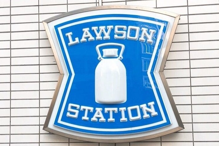 レンガ壁に取り付けられた「LAWSON STATION」のロゴ看板が示されています。
