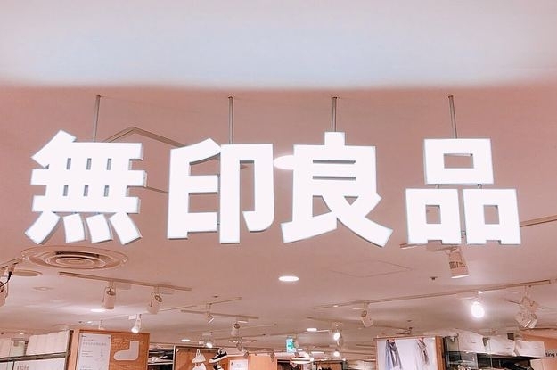 店内に掲示された「無印良品」のサインが光っている様子。