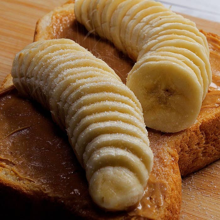 パンの上にピーナッツバターとスライスされたバナナが載っているトースト。