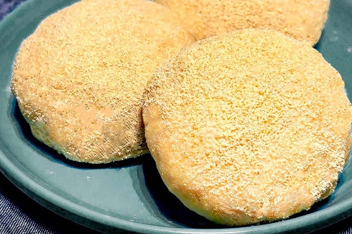 お皿に盛られた3つの黄粉餅が布の上に置かれています。