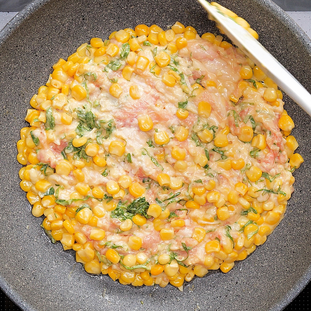 フライパンで調理中のポテトとトウモロコシの混ぜ合わせ料理。