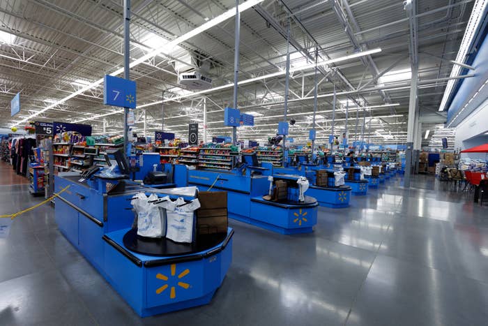 Wide view of a grocery store checkout area with multiple checkout lanes and bagged groceries ready for purchase