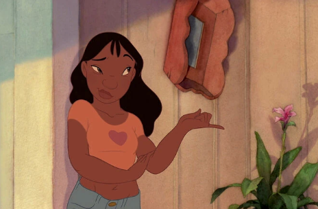 Animated character with long hair, wearing a casual outfit, gestures with one hand, standing near a plant and wall ornament