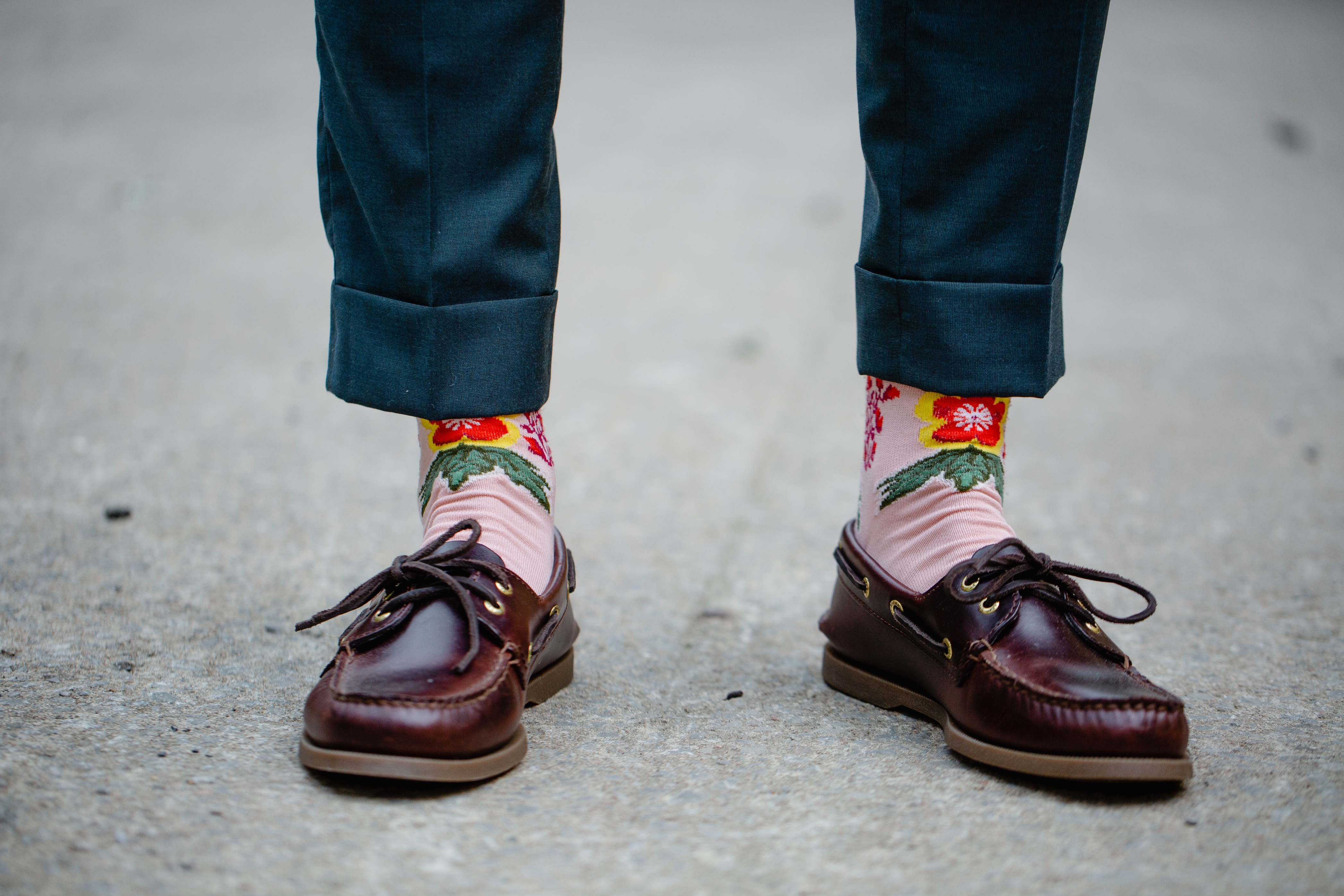 Close-up of a person's feet wearing floral-patterned socks and brown loafers