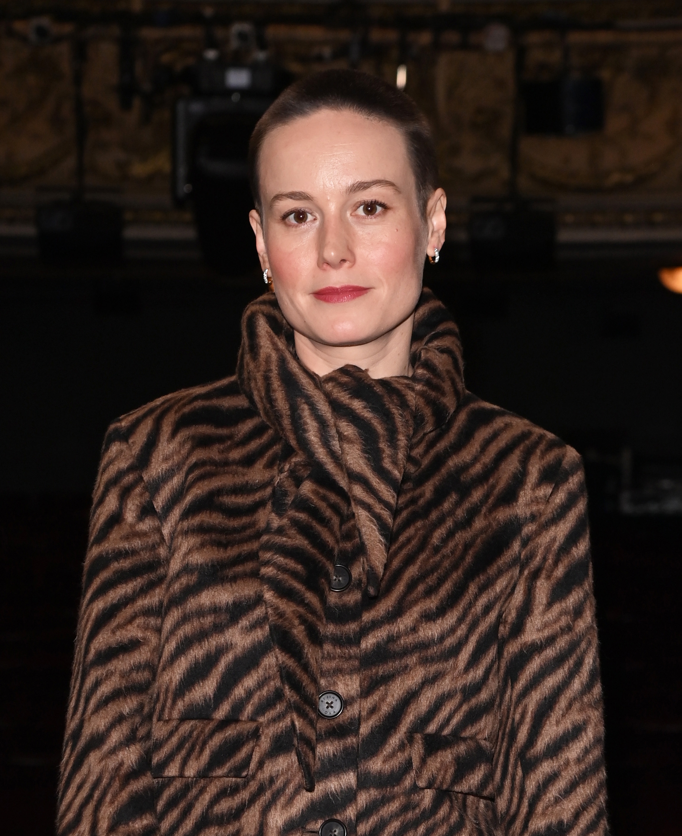 Person in a tiger-patterned coat, posing indoors