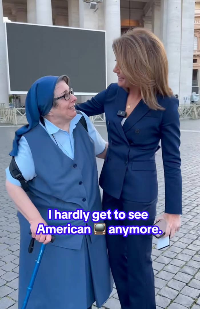 Two women stand smiling; one in a blue habit, the other in a tailored suit. Overlaid text reads, "I hardly get to see American TV anymore."