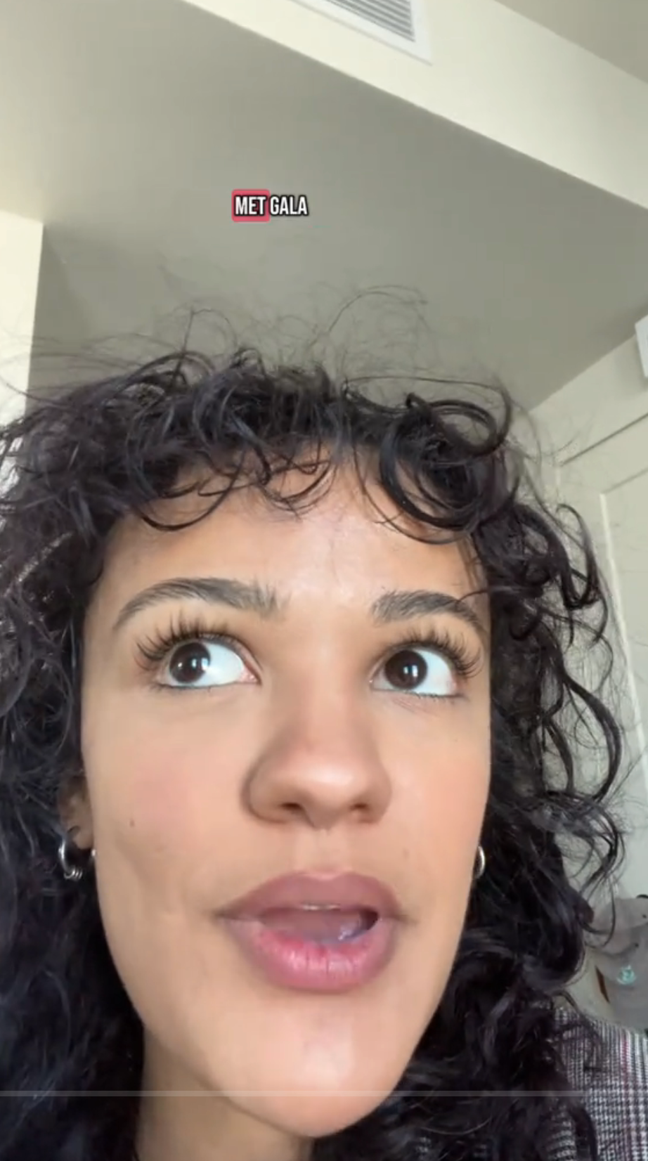 Person with curly hair speaking indoors, text reads "MET GALA" above