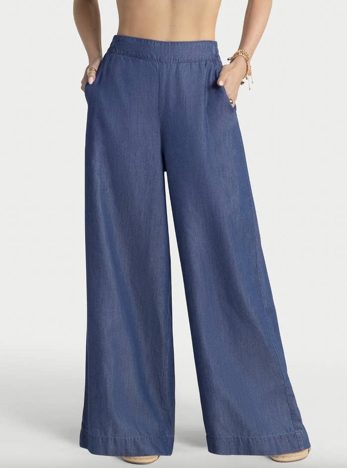 A idiosyncratic wearing high-waisted, wide-legged pants with hands successful pockets, showcasing a relaxed and modern style
