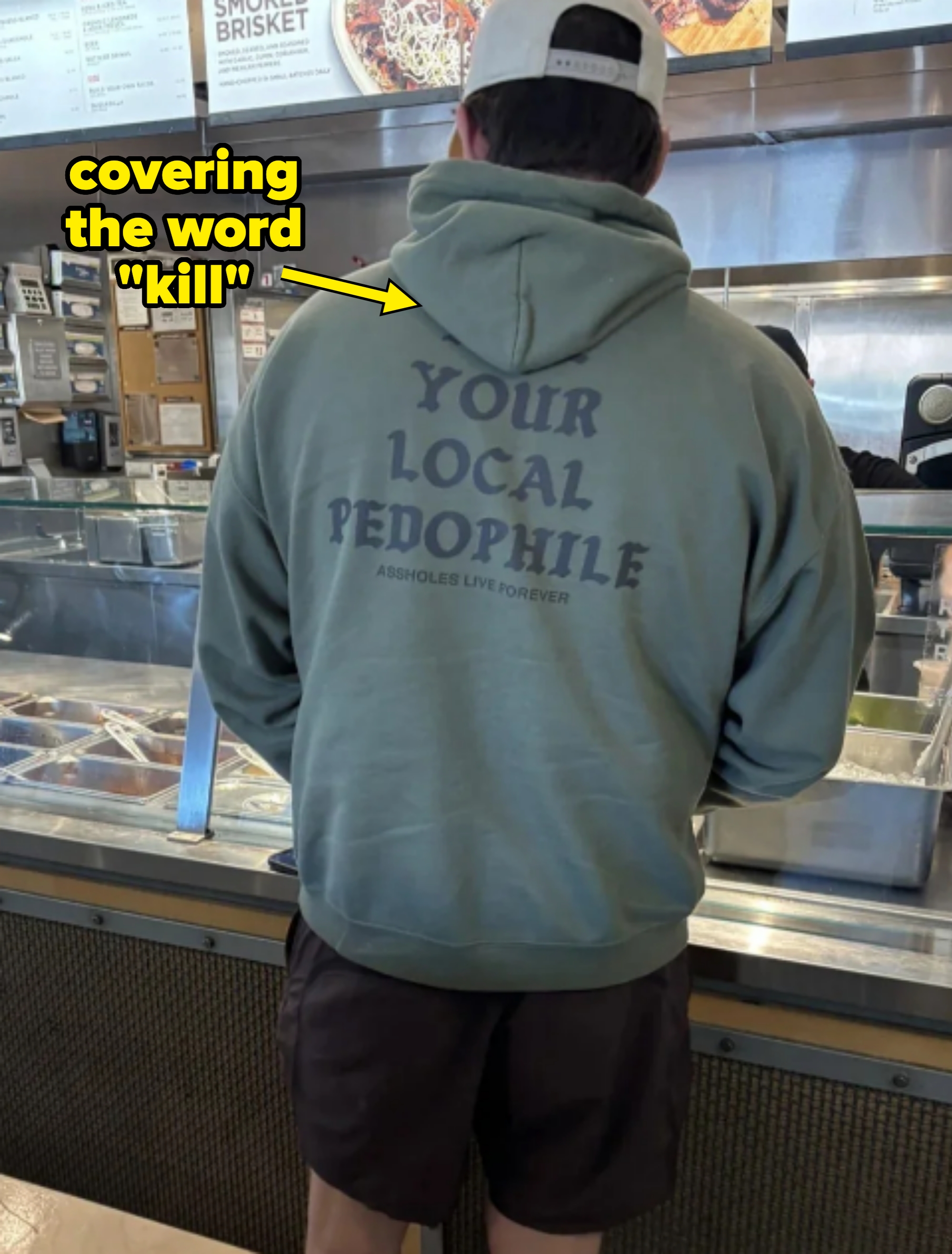 Man at counter wearing hoodie reading "kill your local pedophile." However, the "kill" is covered by the hood