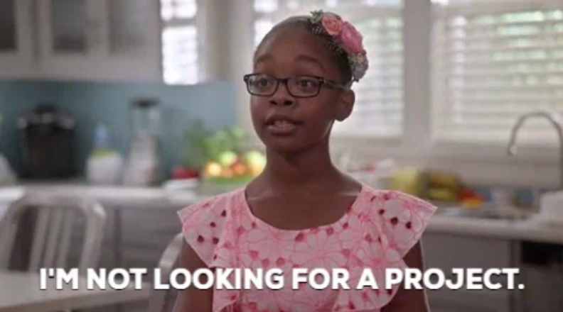 Young girl in glasses with a flower headband, saying, "I'm not looking for a project," in a domestic setting