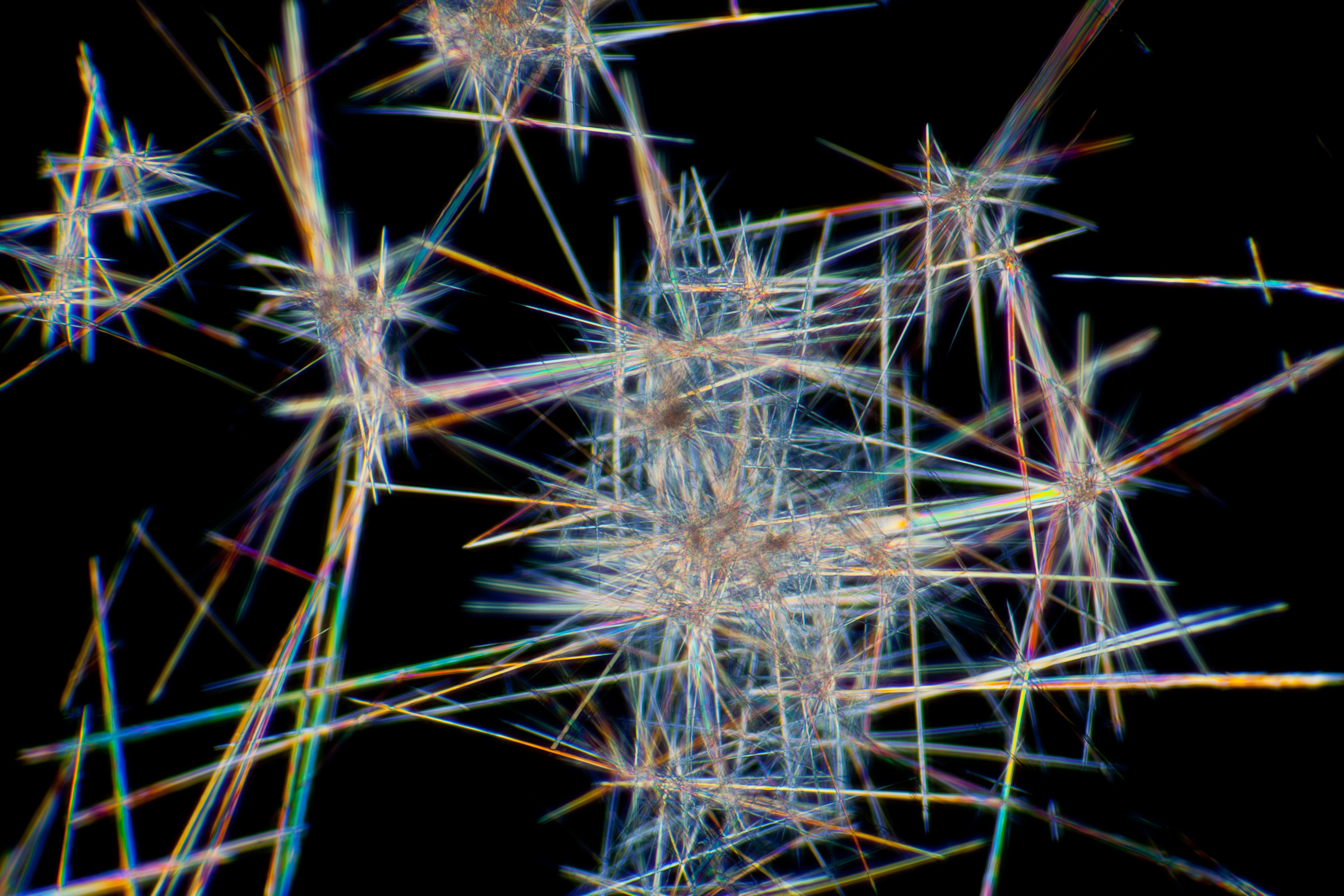 Abstract image of intersecting spikes and lines resembling glass shards on a black background