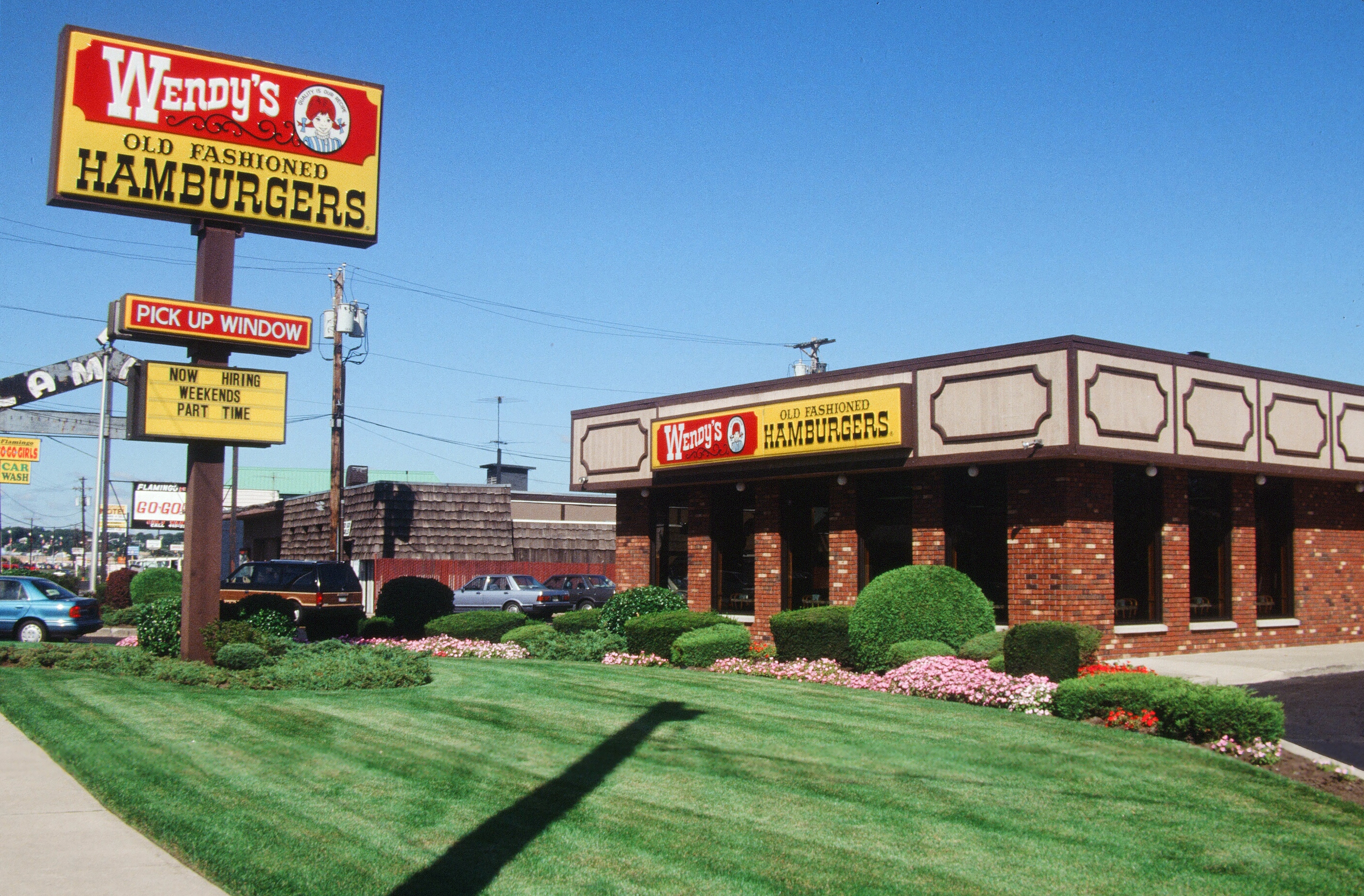 Exterior of a classic Wendy's restaurant with signage for "Old Fashioned Hamburgers" and a "Pick Up Window" advertising drive-thru service