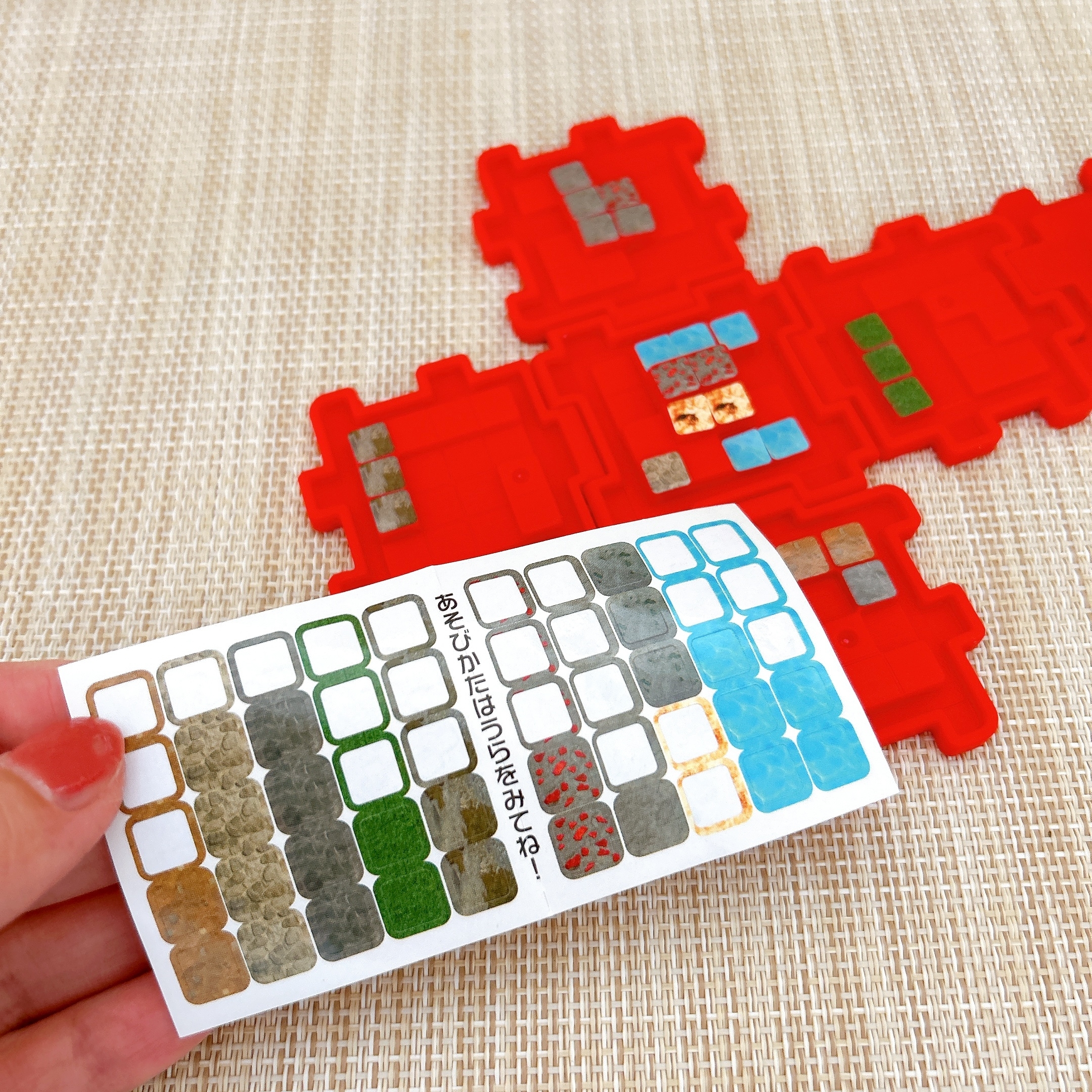 赤いボードと多色の小さなマスを示すサンプルシート。遊び方を紹介するテキスト付き。