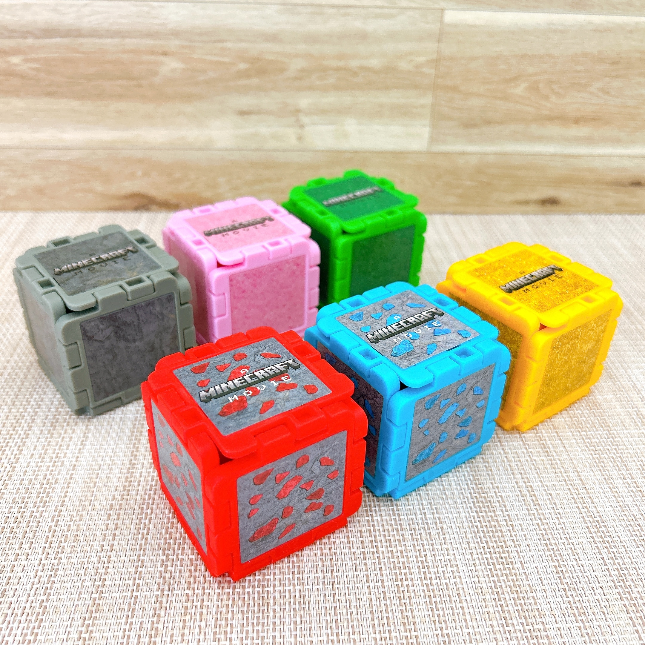 6つのMinecraftテーマのブロックがテーブルに並んでいる。おもちゃやコレクションアイテムとして使用される。