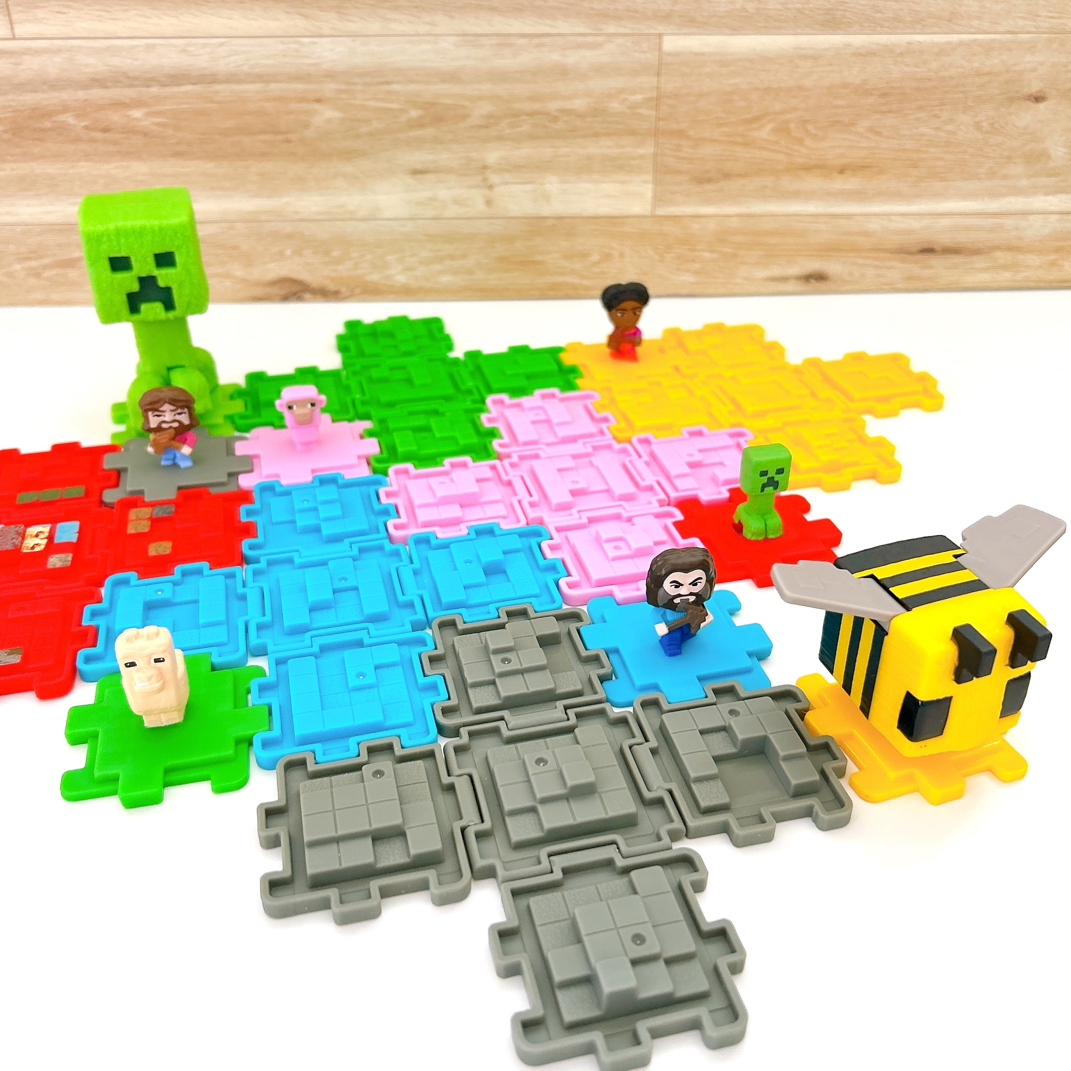 テーブル上にMinecraftのフィギュアとカラフルなパズルピースが配置されている。