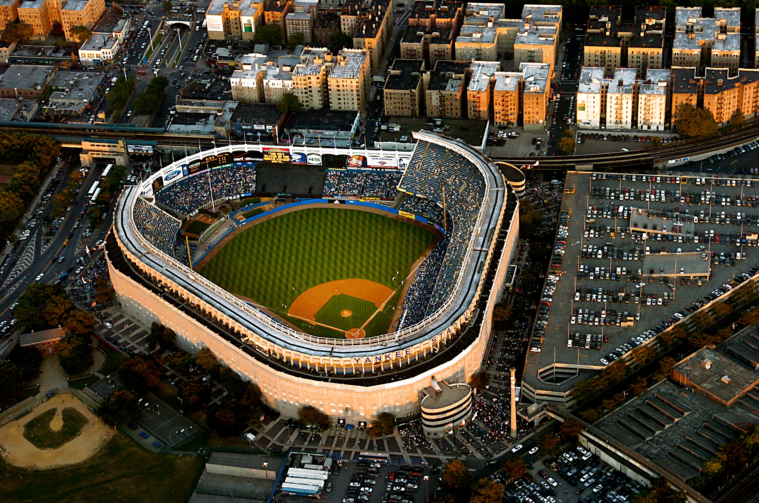 Aerial view of a packed baseball stadium surrounded by city buildings and parking lots