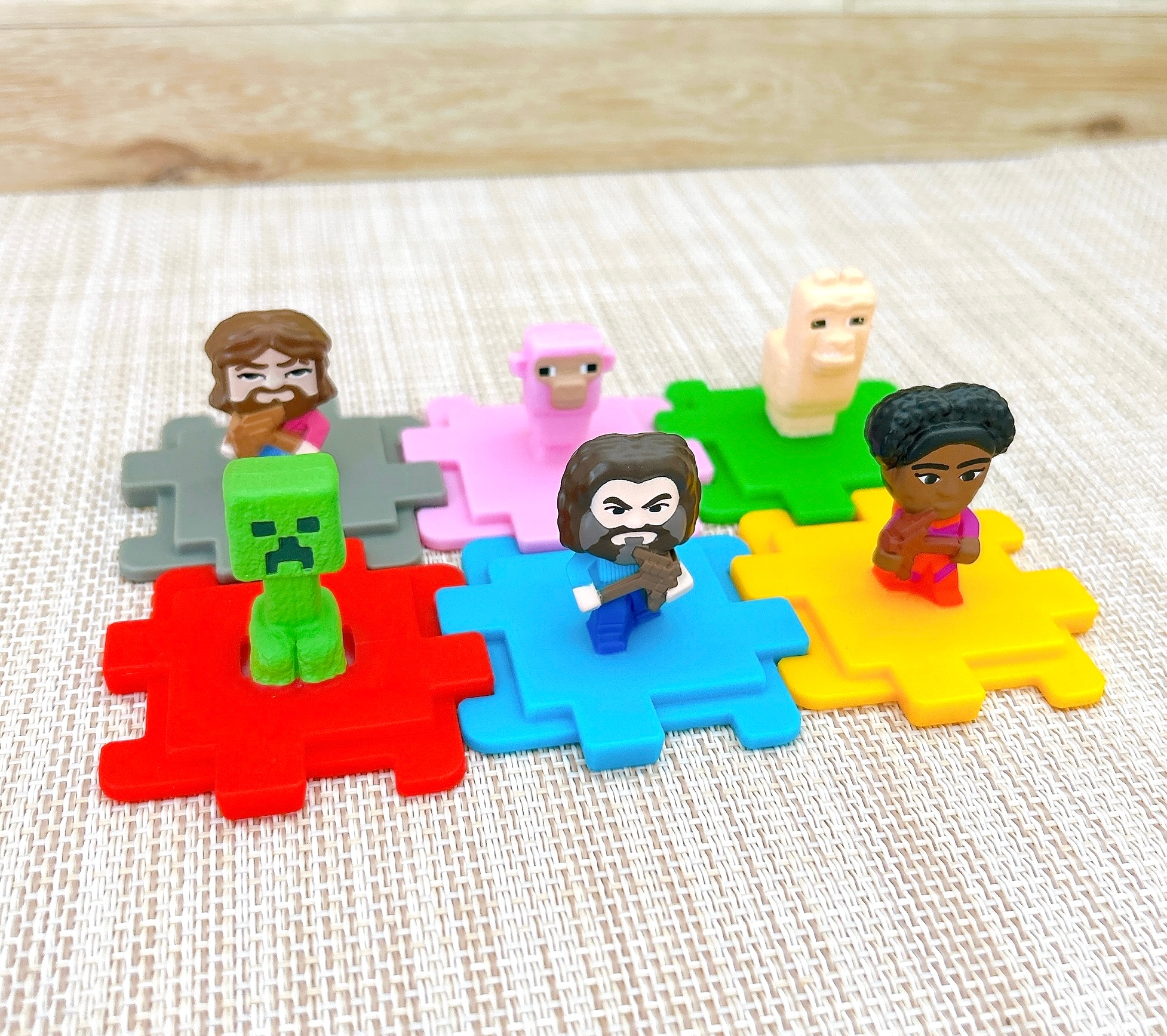 複数のキャラクターが、異なる色のピースの上に座っている様子。テーブル上で並べられている。