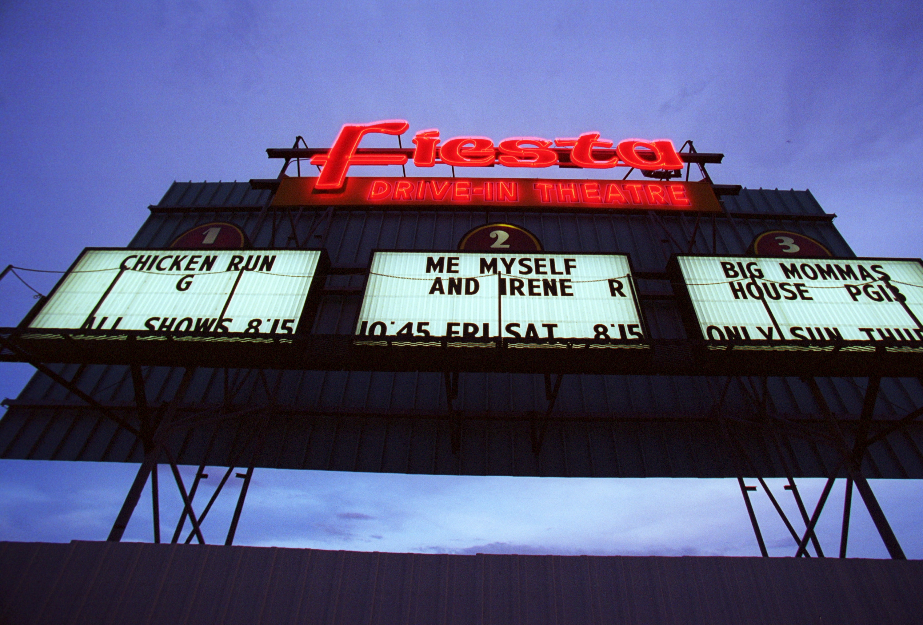 Marquee sign for Fiesta Drive-In Theatre showing films: "Chicken Run," "Me Myself and Irene," and "Big Momma's House."
