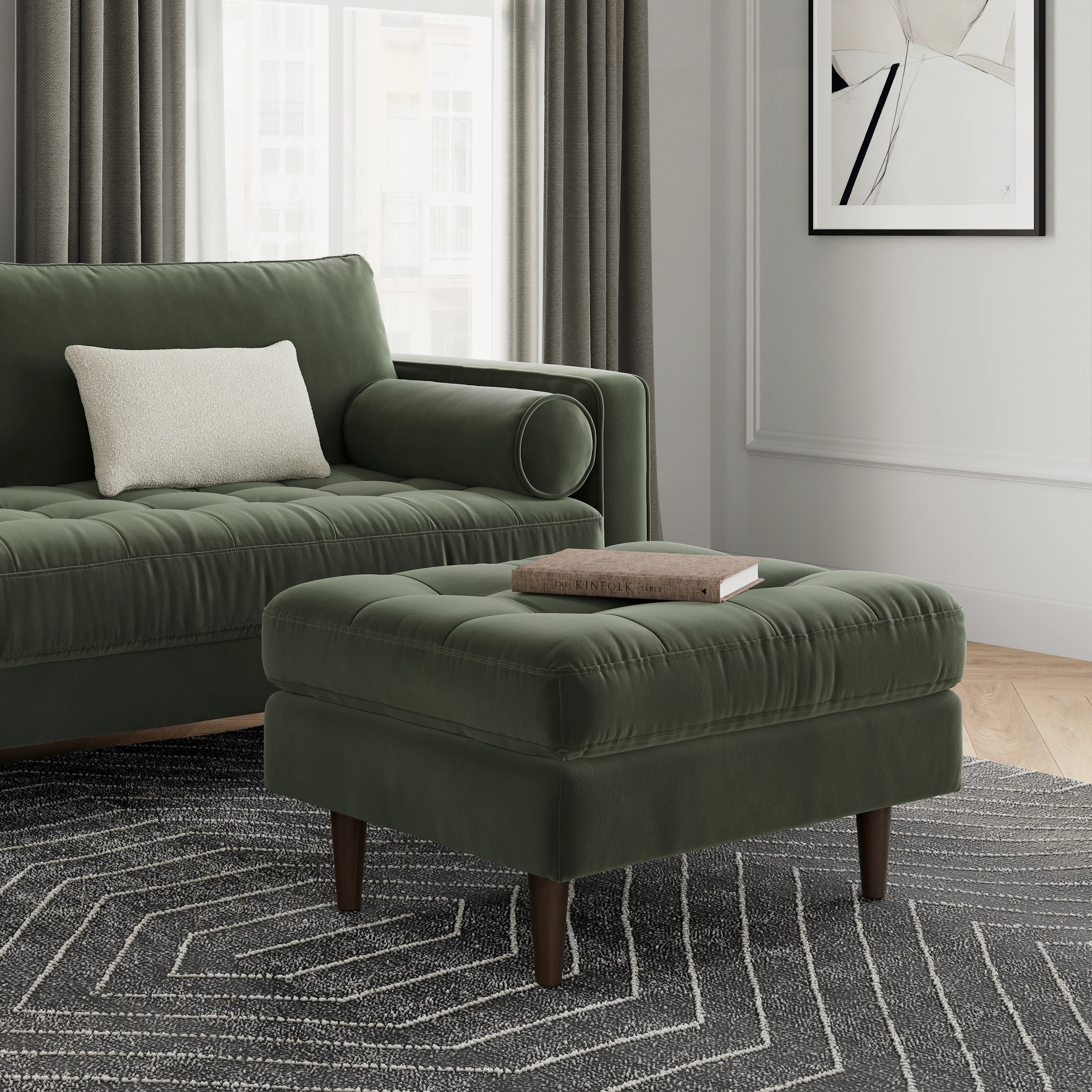 Living room with a plush sofa and matching ottoman on a patterned rug. Modern decor includes framed artwork on the wall