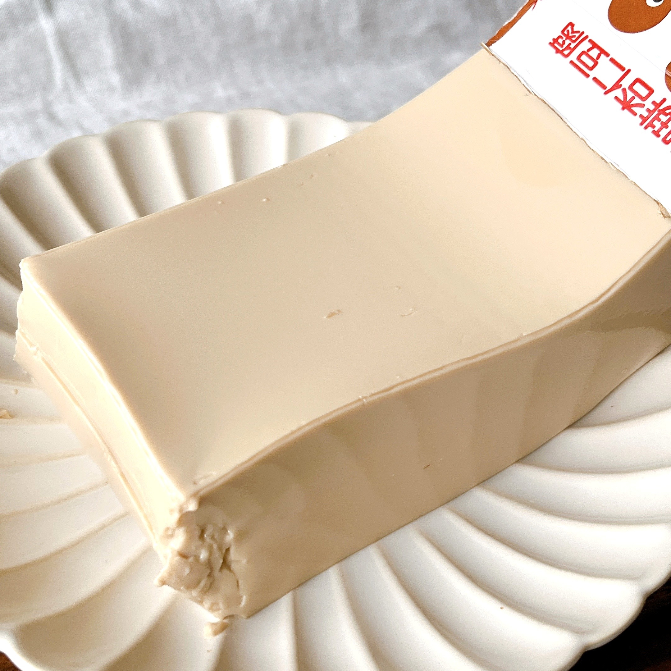 皿の上に乗った厚切りの豆腐が包装から一部出ている。