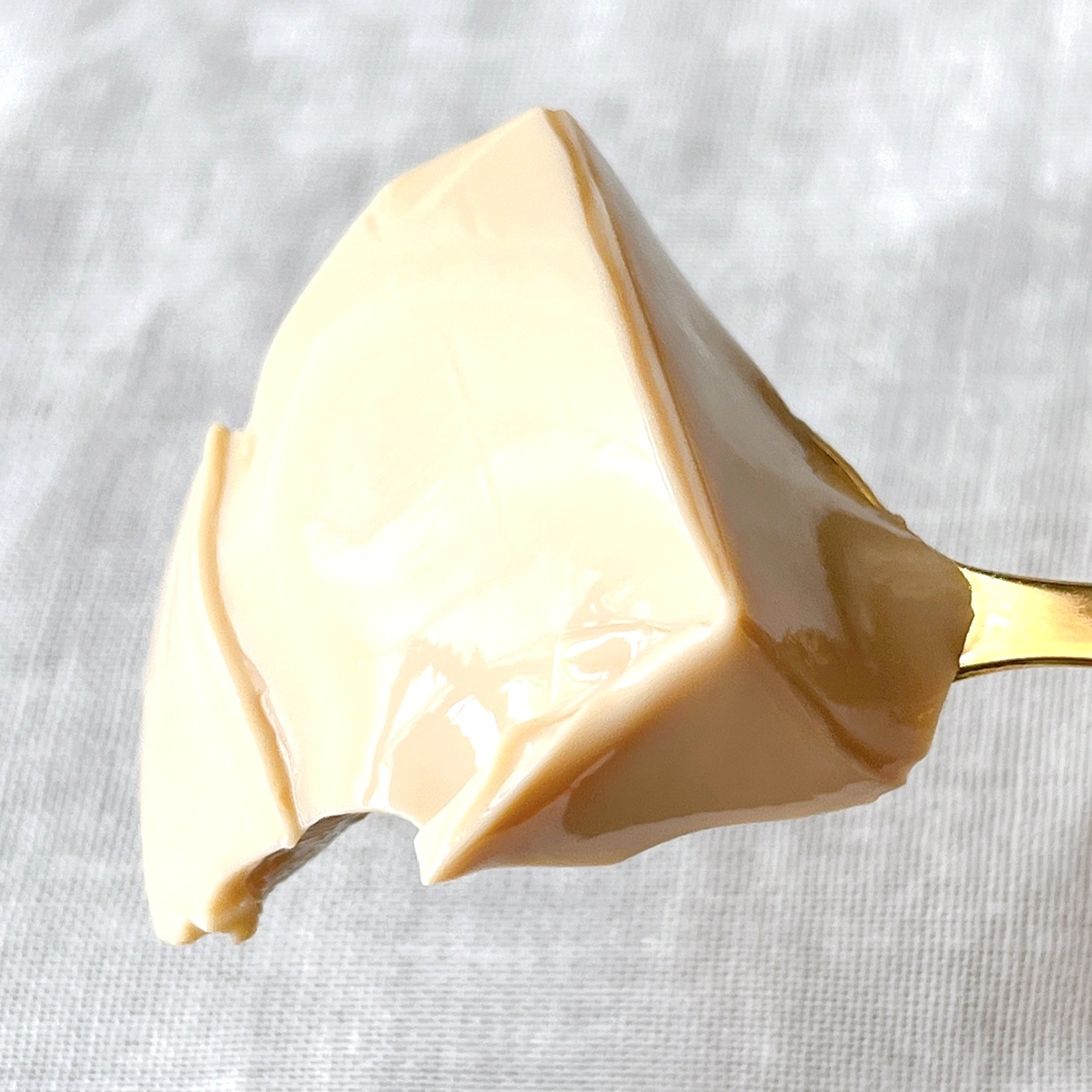 スプーンにのったクリーミーな豆腐の一切れ。