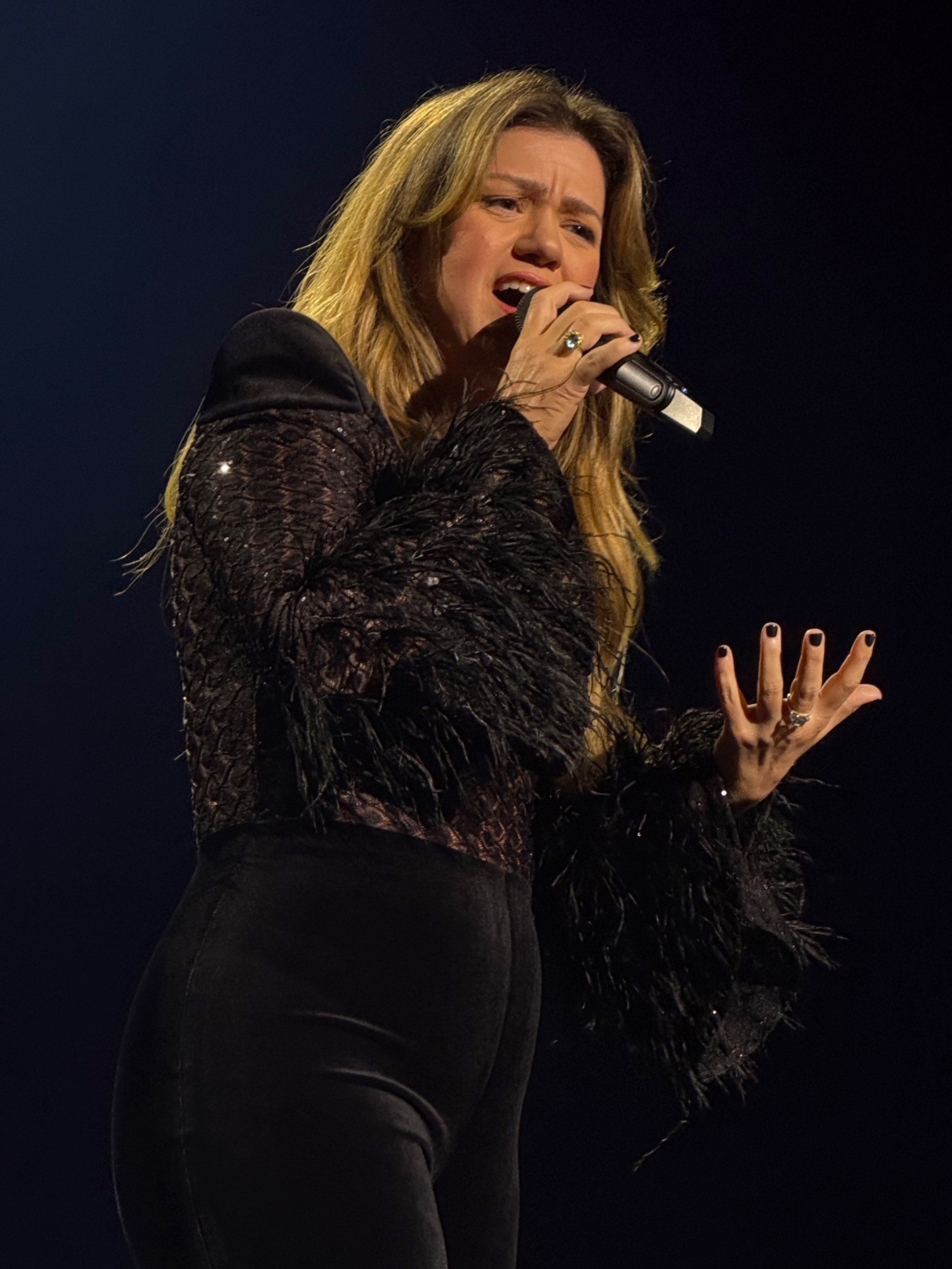 Kelly Clarkson performing passionately on stage