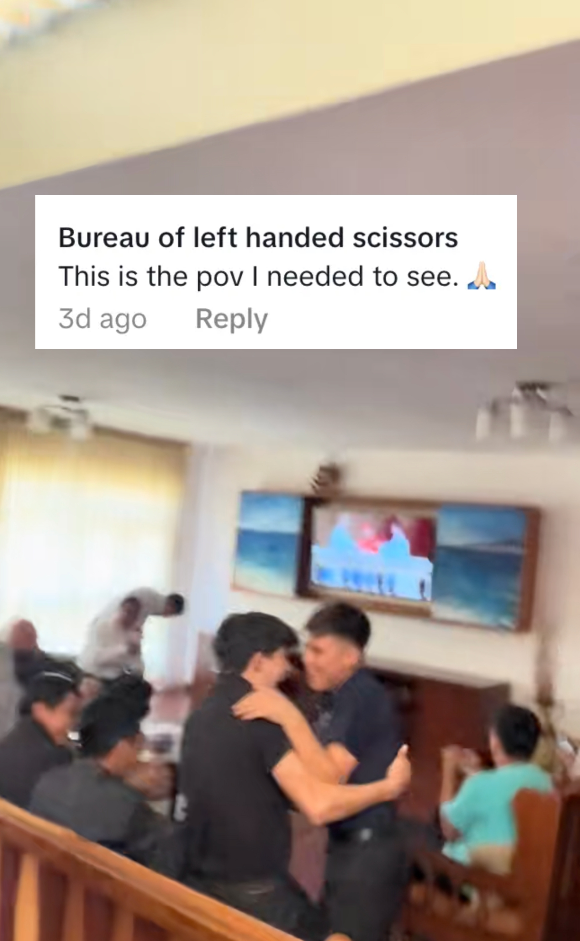 A blurred image shows several people in a living room, some standing and some sitting, with a TV on in the background