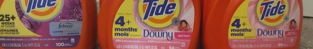 Three large Tide detergent bottles on carpet, labeled for various uses, including Febreze freshness and Downy softness